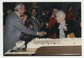 Dr. Desmond with congratulary cake at her retirement party