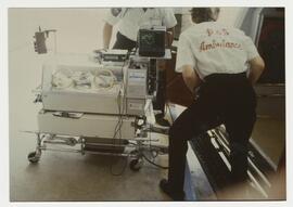 Paramedics load infant incubator into ambulance at Jefferson Davis Hospital