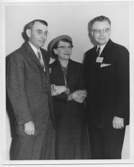 Emmeline J. Renis standing with two men