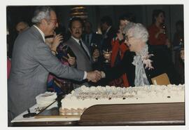 Dr. Desmond with congratulary cake at her retirement party